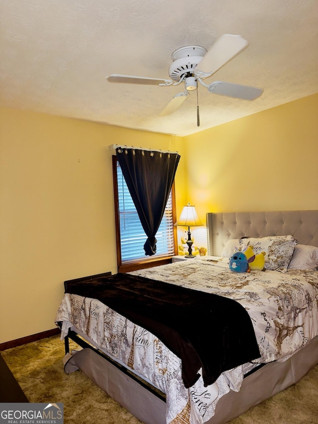 bedroom with ceiling fan, carpet, and a textured ceiling