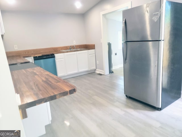 kitchen with wooden counters, white cabinets, sink, light hardwood / wood-style flooring, and stainless steel appliances