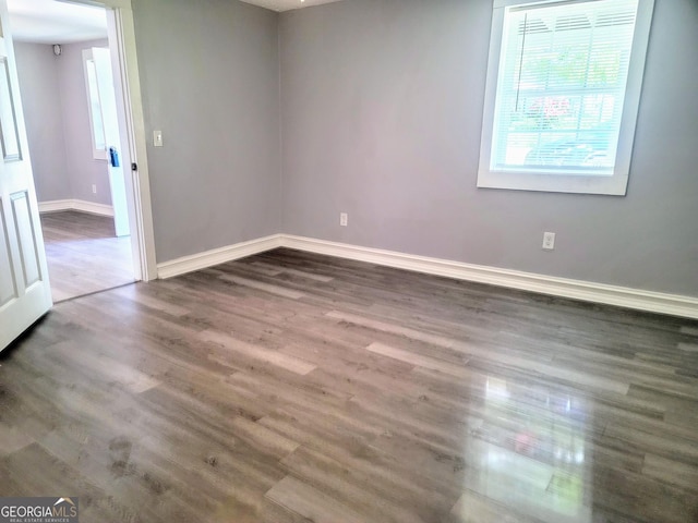 empty room with dark hardwood / wood-style flooring