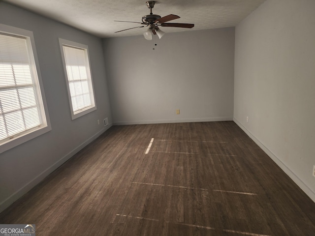 unfurnished room with a textured ceiling, ceiling fan, and dark wood-type flooring