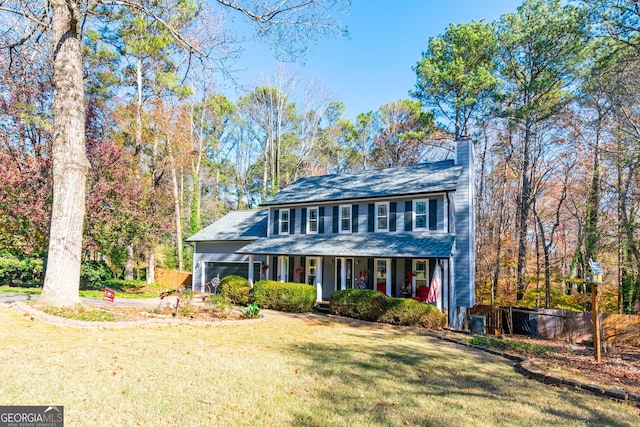 view of front of property with a porch, a garage, and a front lawn