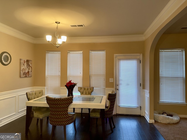 dining room with a chandelier, dark wood-type flooring, and ornamental molding