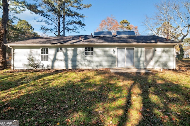 back of house featuring a lawn