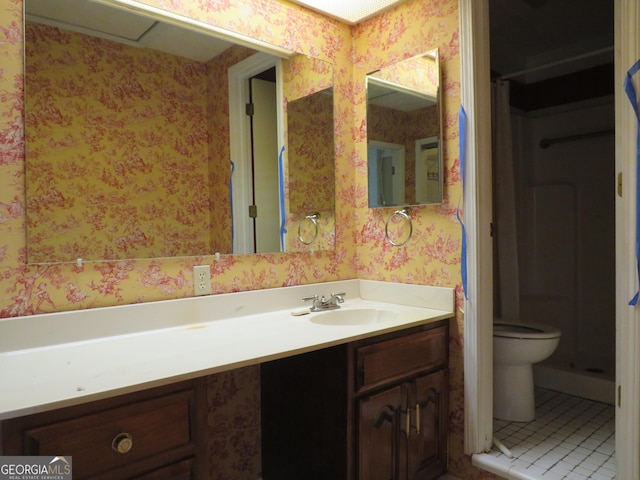 bathroom with tile patterned flooring, vanity, and toilet