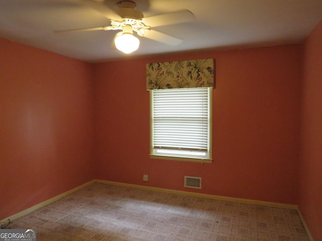 unfurnished room with light colored carpet and ceiling fan