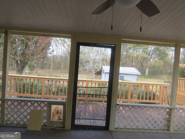 unfurnished sunroom featuring ceiling fan and a healthy amount of sunlight