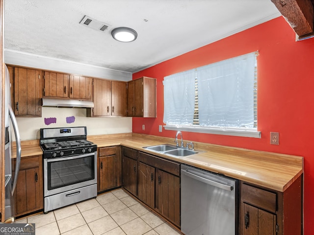 kitchen with sink, light tile patterned flooring, and appliances with stainless steel finishes