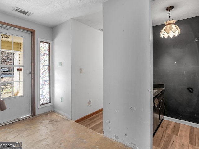 foyer entrance featuring light hardwood / wood-style flooring and a textured ceiling