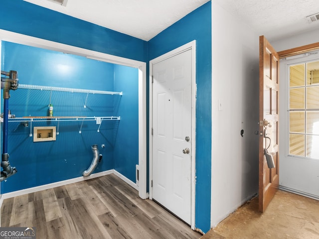 clothes washing area with washer hookup, hardwood / wood-style floors, and a textured ceiling