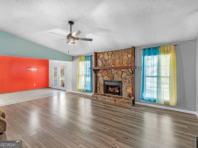 unfurnished living room featuring plenty of natural light, wood-type flooring, and lofted ceiling