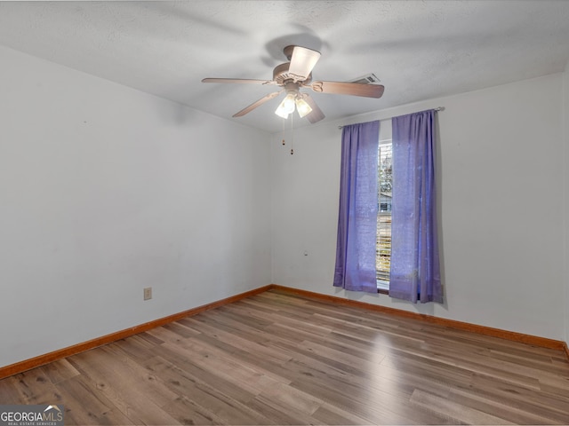 unfurnished room featuring ceiling fan, hardwood / wood-style floors, and a textured ceiling