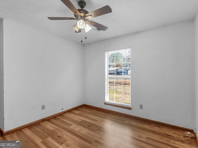 spare room featuring ceiling fan, wood-type flooring, and a textured ceiling