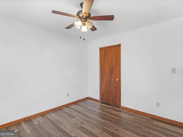 spare room featuring ceiling fan and dark wood-type flooring