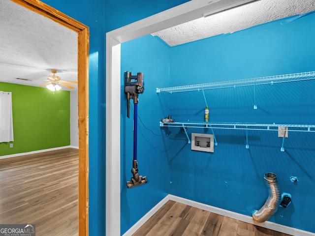 laundry area featuring ceiling fan, wood-type flooring, a textured ceiling, and hookup for a washing machine