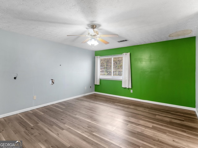 empty room featuring a textured ceiling, hardwood / wood-style flooring, and ceiling fan