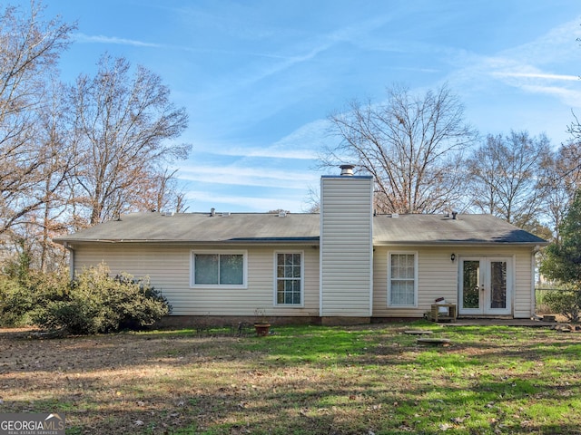 rear view of property featuring french doors and a yard