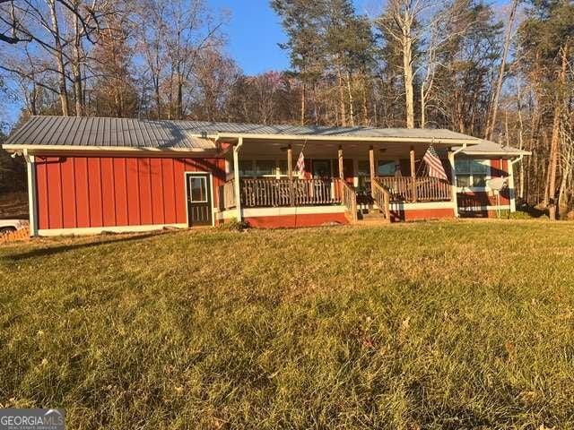 ranch-style home with covered porch and a front lawn