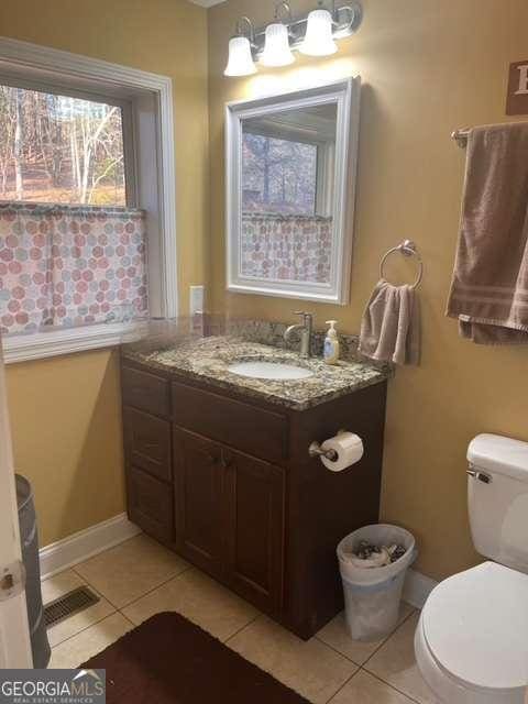 bathroom with tile patterned floors, vanity, and toilet