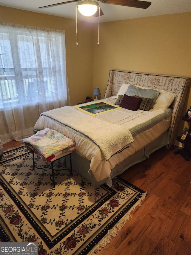 bedroom with ceiling fan and dark hardwood / wood-style flooring