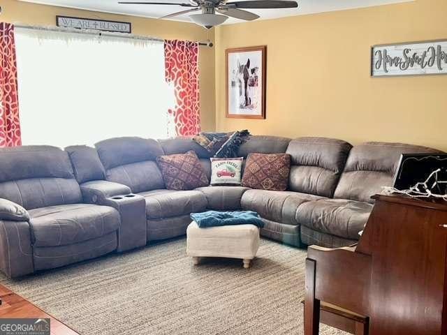 living room with hardwood / wood-style flooring and ceiling fan