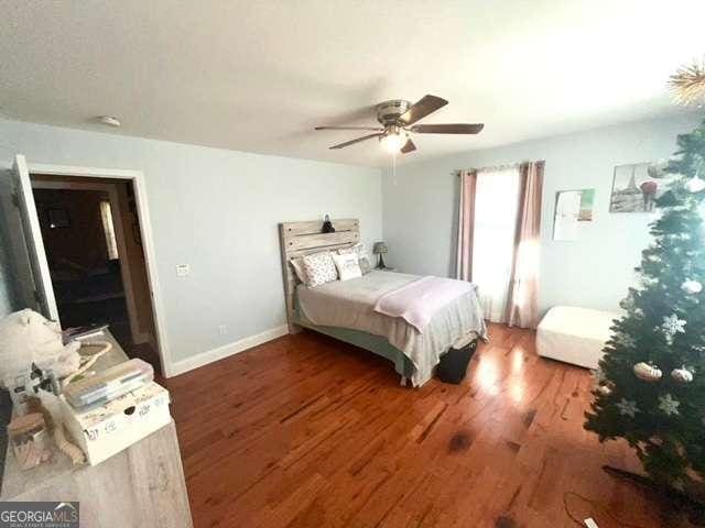 bedroom featuring ceiling fan and dark wood-type flooring