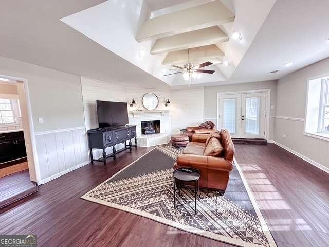 living room with dark hardwood / wood-style floors, ceiling fan, and a healthy amount of sunlight