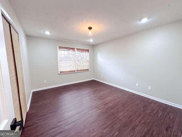 unfurnished bedroom featuring dark wood-type flooring and a closet