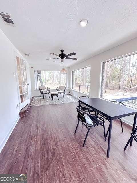 interior space with ceiling fan, a textured ceiling, and hardwood / wood-style flooring