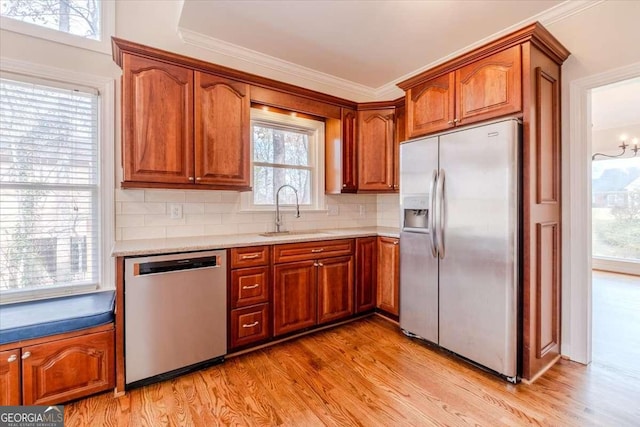 kitchen featuring stainless steel appliances, a wealth of natural light, light hardwood / wood-style floors, and sink