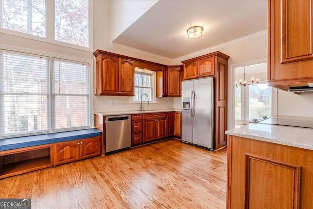 kitchen with a healthy amount of sunlight, sink, stainless steel appliances, and light hardwood / wood-style flooring