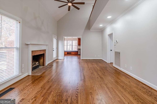 unfurnished living room with plenty of natural light, wood-type flooring, and a fireplace