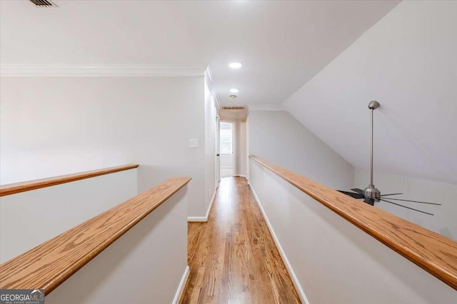 hall with lofted ceiling, crown molding, and light hardwood / wood-style flooring