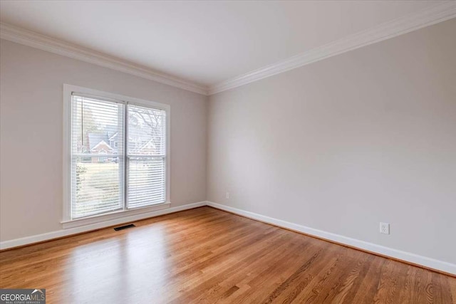 unfurnished room with light wood-type flooring and crown molding