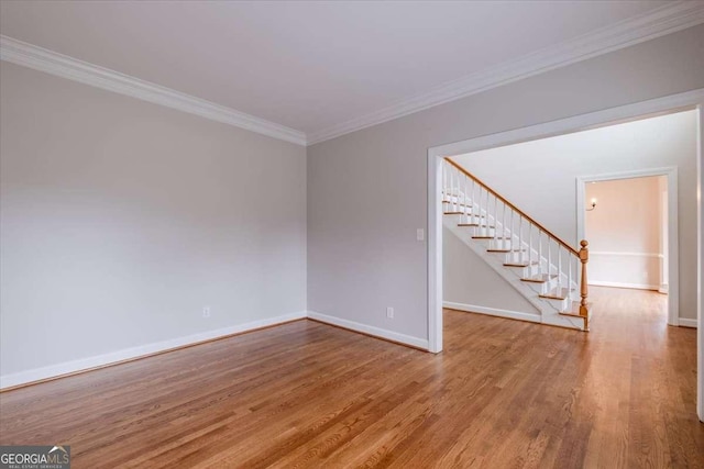 empty room with hardwood / wood-style floors and ornamental molding