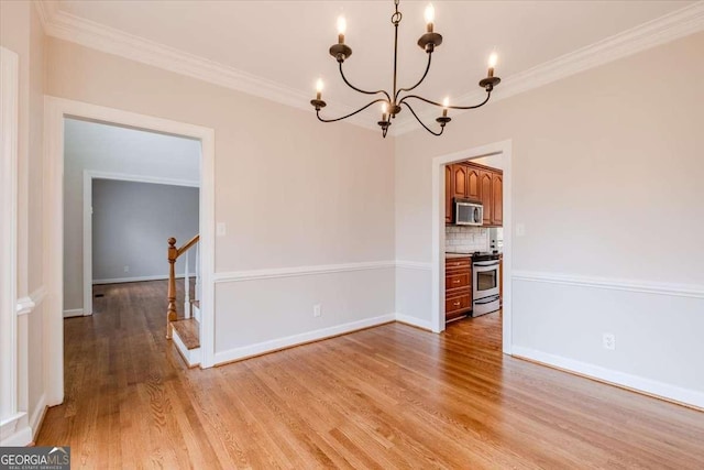 unfurnished dining area featuring a chandelier, ornamental molding, and light hardwood / wood-style flooring