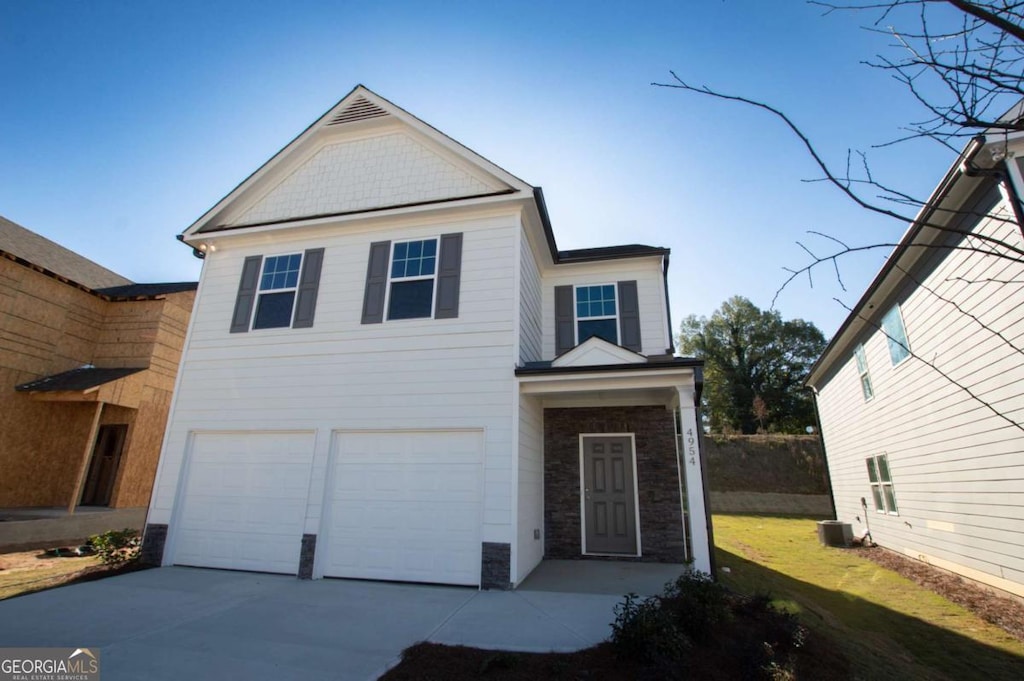 view of front property featuring central AC and a garage