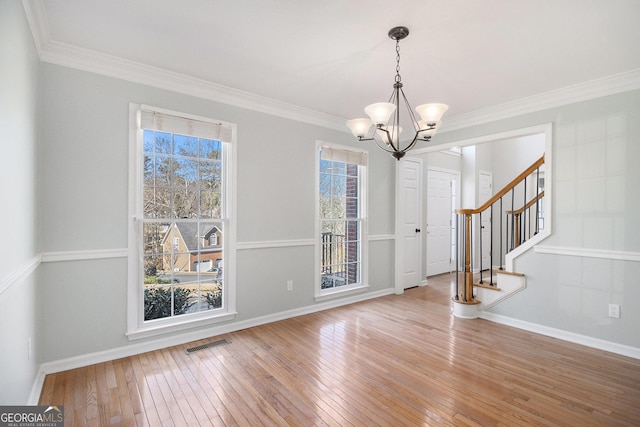 interior space with hardwood / wood-style flooring, crown molding, and a notable chandelier