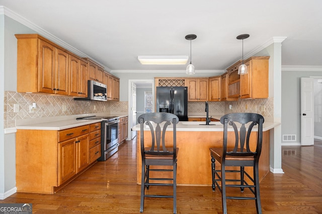 kitchen with decorative backsplash, appliances with stainless steel finishes, crown molding, and a kitchen breakfast bar