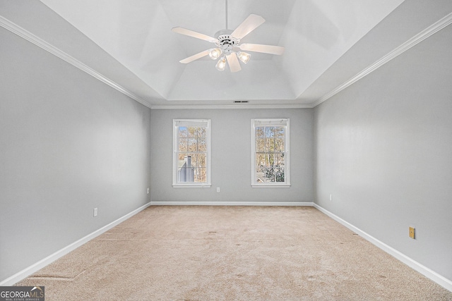 carpeted empty room with a tray ceiling, ceiling fan, and ornamental molding