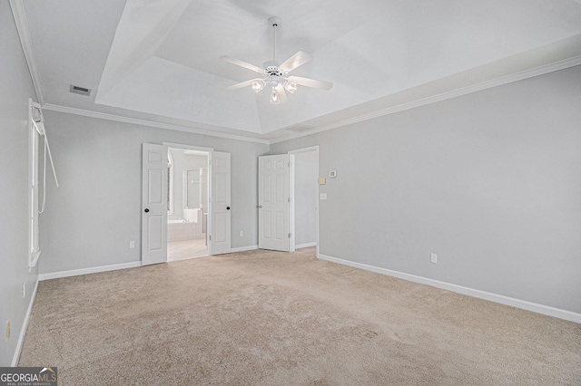 unfurnished bedroom featuring carpet, a tray ceiling, ceiling fan, and crown molding