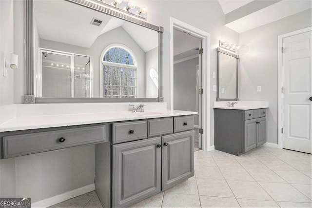 bathroom with tile patterned floors, vanity, an enclosed shower, and vaulted ceiling