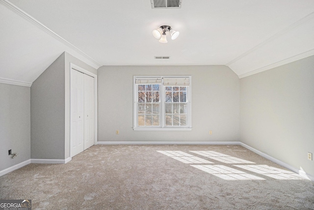 bonus room with lofted ceiling and light carpet