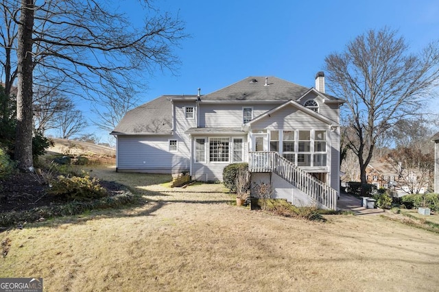 rear view of property with a lawn and a sunroom