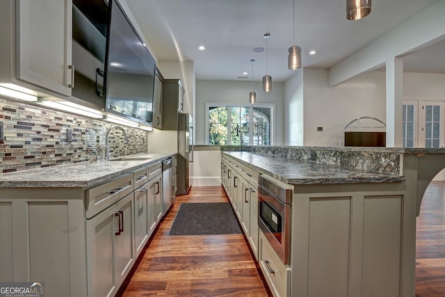 kitchen with decorative light fixtures, dark hardwood / wood-style floors, gray cabinetry, and sink