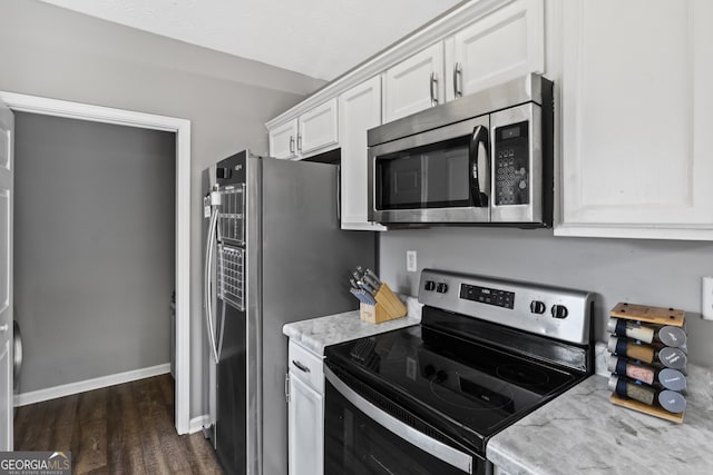 kitchen featuring white cabinets, appliances with stainless steel finishes, dark hardwood / wood-style flooring, and light stone countertops