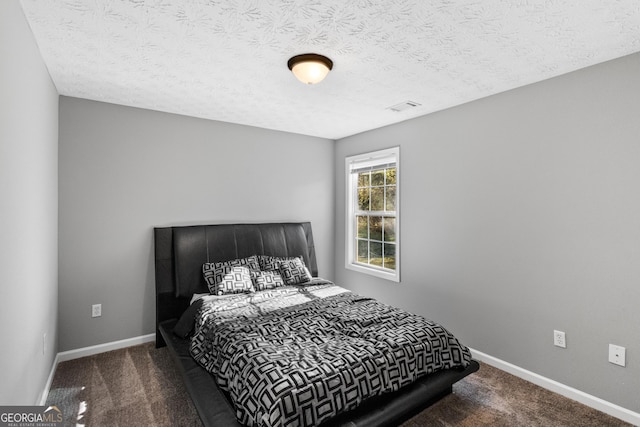 carpeted bedroom featuring a textured ceiling