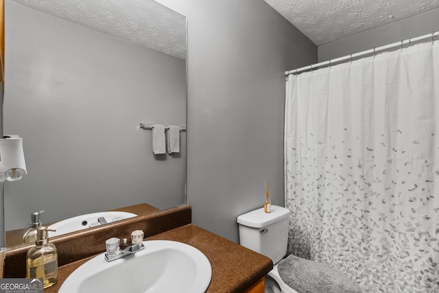 bathroom featuring a shower with shower curtain, vanity, toilet, and a textured ceiling