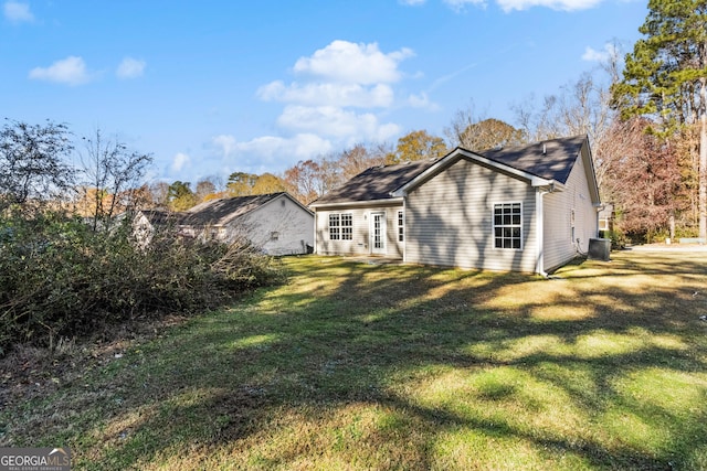 back of property with a lawn and central AC unit