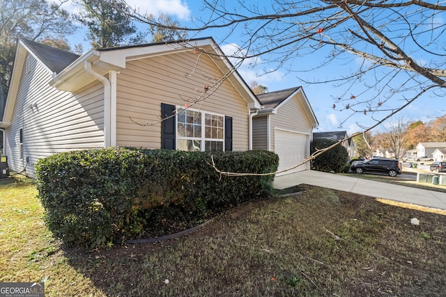 view of side of home with central AC unit, a garage, and a yard