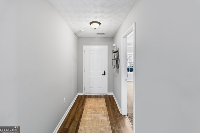 doorway featuring dark hardwood / wood-style flooring and a textured ceiling